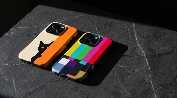 The Curious Cat and No Signal TV iPhone tough cases on dark stone with long shadows in low autumn light